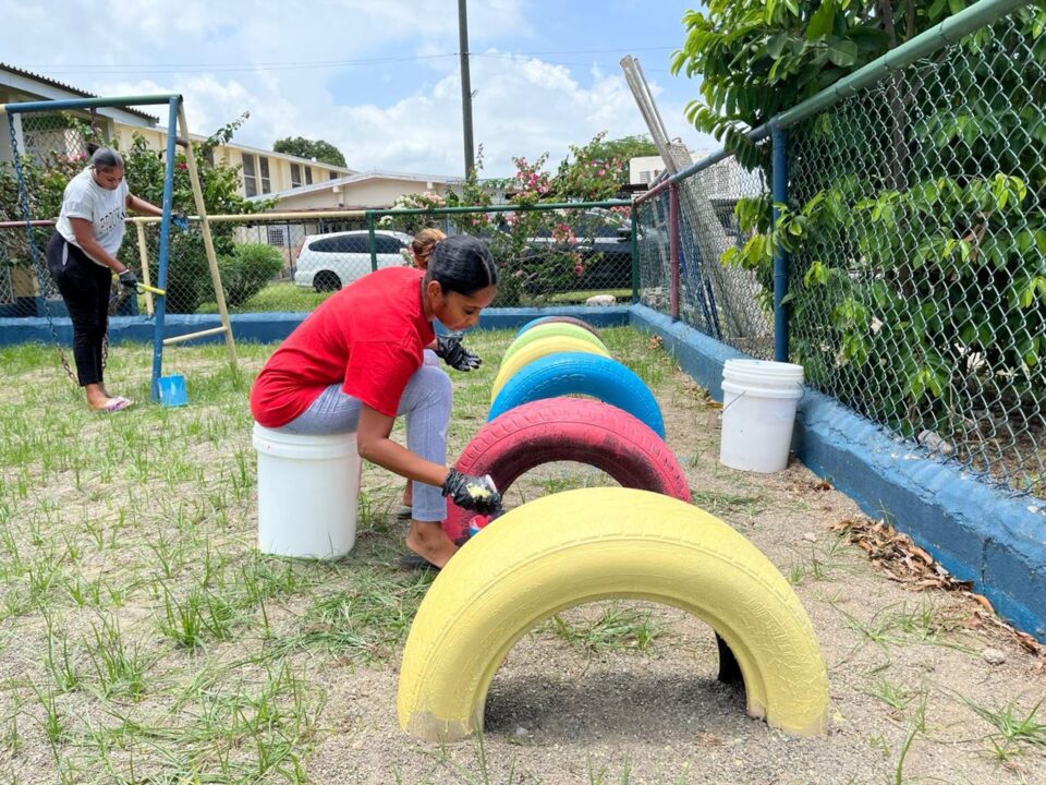 TransparentBPO volunteers painting playground tyres during a Jamaica outreach day